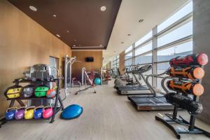 a gym with several treadmills and cardio machines at Barceló Malaga in Málaga