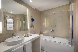a bathroom with a sink and a shower and a tub at Barceló Malaga in Málaga