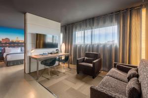 a hotel room with a desk and a bed at Barceló Malaga in Málaga