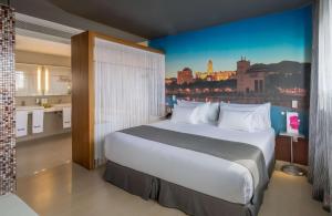 a bedroom with a large bed with a view of a city at Barceló Malaga in Málaga