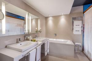 a bathroom with two sinks and a tub and a mirror at Barceló Malaga in Málaga