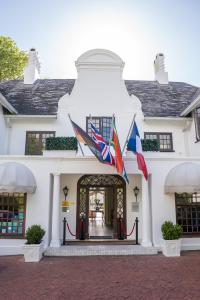 a white building with flags flying in front of it at The Andros Boutique Hotel in Cape Town