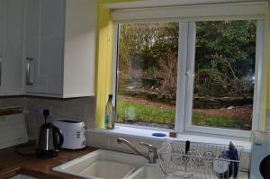 um balcão de cozinha com um lavatório e uma janela em The Side - Hexham em Hexham