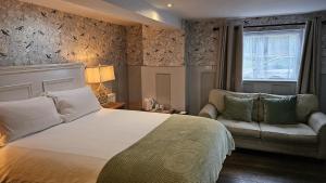 1 dormitorio con cama, sofá y ventana en College Arms en Stratford-upon-Avon