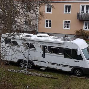 uma carrinha branca estacionada em frente a uma casa em Husbil centralt em Kalmar