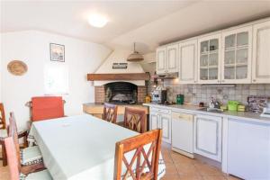 a kitchen with a table and chairs and a fireplace at Villa Ana in Zadar