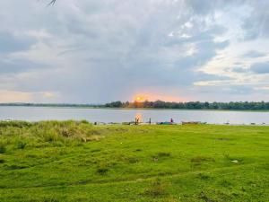 einen Blick auf einen See mit der Sonne in der Ferne in der Unterkunft Hotel Lake Park in Polonnaruwa