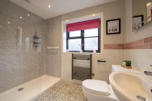 a bathroom with a toilet and a tub and a sink at Oak Lodge House in Leyburn +24 photos
