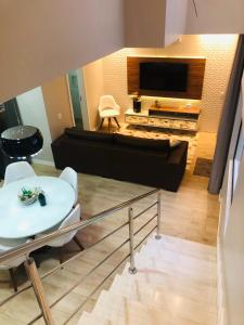 uma sala de estar com um sofá e uma televisão em Casa Luxo com piscina a 500 metros da praia em Florianópolis