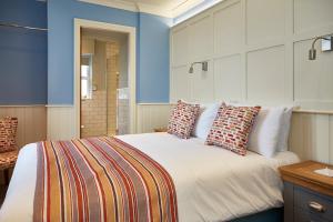 um quarto com uma grande cama branca com almofadas em Trearddur Bay Hotel em Trearddur