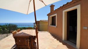 une terrasse avec une table et un parasol dans l'établissement Apartment I Nidi dei Cormorani, à Costa Rei