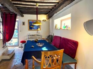 ein Esszimmer mit einem blauen Tisch und roten Stühlen in der Unterkunft Accogliente Dimora Panoramica Civita di Bagnoregio in Bagnoregio