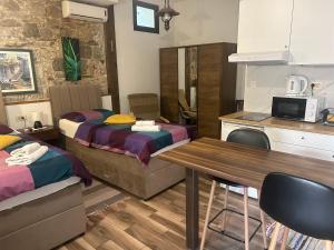 a room with two beds and a table and a kitchen at Elena Rooms Split in Split