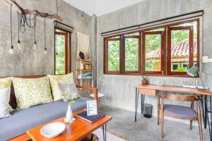 a living room with a couch and a desk at Boutique Jungle Villa - Baan ChaOm in Ko Lanta +18 photos