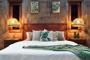a bedroom with a large white bed with two lamps at Boutique Jungle Villa - Baan ChaOm in Ko Lanta