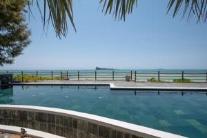 勒拉芒丹的住宿－Luxury beachfront duplex, Coin de Mire view / 3Bed，一座背景海洋的游泳池
