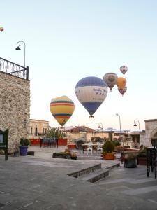 a group of hot air balloons in a courtyard at Canela Cave Hotel - Cappadocia in Göreme