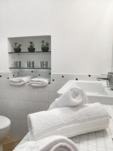 een badkamer met een bad, een toilet en handdoeken bij MARCONA 1 - City Centre Apt with Terrace in Milaan