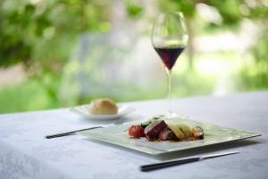 un piatto di cibo e un bicchiere di vino su un tavolo di Tateshina Tokyu Hotel a Chino