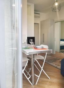 een eetkamer met een witte tafel en stoelen bij MARCONA 1 - City Centre Apt with Terrace in Milaan