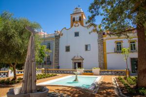 a building with a fountain in front of it at Casa do Ferrador in Moura