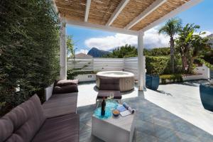 un patio con un divano e un tavolo di I Tre Golfi - Villa Iride a San Vito lo Capo
