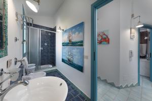 un bagno con wc, lavandino e doccia di I Tre Golfi - Villa Iride a San Vito lo Capo Altre 20 foto