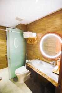 a bathroom with a toilet and a sink and a mirror at Rustic Hotel Quy Nhon Powered by ASTON in Quy Nhon