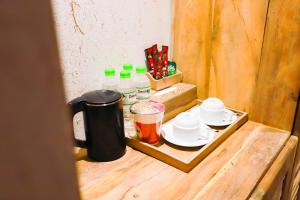 a table with a tray of milk and cups at Rustic Hotel Quy Nhon Powered by ASTON in Quy Nhon