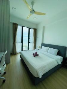 Jazz Suite Ocean View Netflix SmartTV في Tanjong Tokong: غرفة نوم مع سرير أبيض كبير مع مروحة سقف