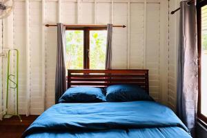 閣遙島的住宿－Lamsai AC Sea House，窗户客房内的一张带蓝色床单的床
