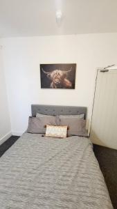 a bed in a bedroom with a picture on the wall at North London Property in London