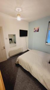 a bedroom with a bed and a flat screen tv at North London Property in London
