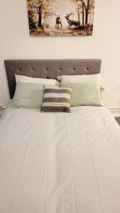 a large white bed with two pillows on it at North London Property in London