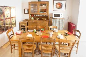 una mesa de comedor de madera con sillas y una cocina en Le Lapin dans la Cour, en Tain-lʼHermitage