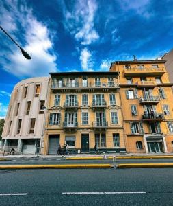 duży żółty budynek po stronie ulicy w obiekcie AngeVert HolidayHouse w Nicei