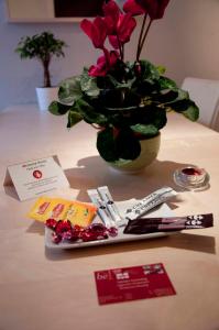 una mesa con un jarrón lleno de flores y tarjetas en Room in Apartment - Condo Gardens Leuven - Student Studio Single en Leuven