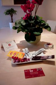 a table with a vase filled with flowers and cards at Room in Apartment - Condo Gardens Leuven - Student Studio Single in Leuven