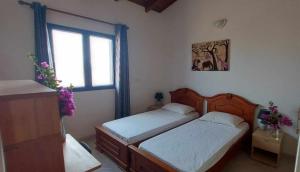 a bedroom with two beds and a window at Casa Torre in Palmeira
