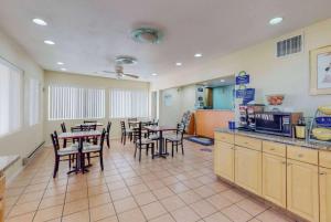 a restaurant with tables and chairs and a kitchen at Days Inn by Wyndham Socorro in Socorro
