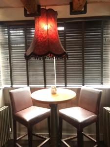 een tafel en twee stoelen en een lamp in een kamer bij The Three Pigeons Inn in Banbury