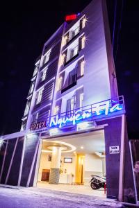 a hotel with a neon sign on the side of it at Nguyen Ha Hotel in Vung Tau