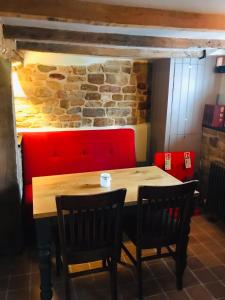 een tafel met twee stoelen en een bakstenen muur bij The Three Pigeons Inn in Banbury