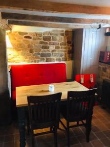 a table with two chairs and a brick wall at The Three Pigeons Inn in Banbury