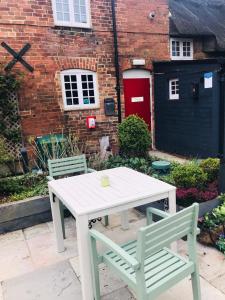 a white table and two chairs in front of a building at The Three Pigeons Inn in Banbury