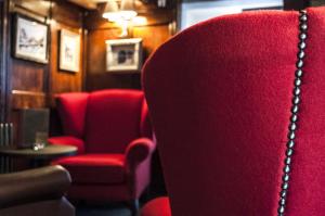 a red chair and a red chair with a chain on it at The Three Pigeons Inn in Banbury