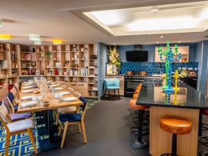 a large dining room with a long table and chairs at Novotel Orléans Sud La Source in Orléans