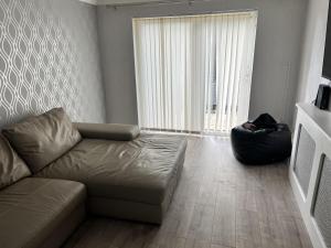 een woonkamer met een bank en een groot raam bij Remarkable 3-Bed House in Basildon in Basildon