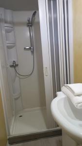 a white bathroom with a shower and a sink at Bolsena Holiday House in Bolsena
