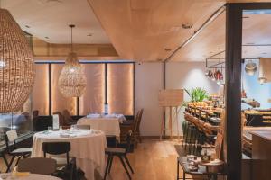 a restaurant with white tables and chairs and windows at Zenit Convento San Martin in Donostia-San Sebastián
